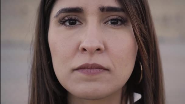 Szabadtéri portré egy latin nőről, aki komoly arccal néz a kamerába. Egy emberi arc közelsége. Az emberek és érzelmek fogalma. — Stock videók