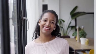 Ofiste durmuş kameraya bakan neşeli, güzel Afrikalı kadın profesyonel. Mutlu, kendine güvenen girişimci bayan gülen surat tek başına poz veriyor.