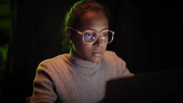 ラップトップをハッキングしてる。女性はハッカー攻撃を行う。インターネットセキュリティコンセプト-暗い部屋の画面デバイスの反射ゴーグルでギーク-コンピュータオタク。コンピュータの前にいる女性. — ストック動画