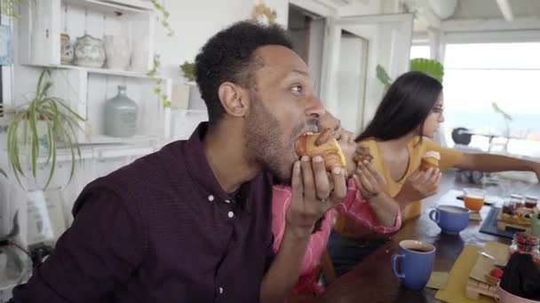 Hombre afroamericano desayunando con amigos. Afro chico comiendo pastel con su novia — Vídeo de stock
