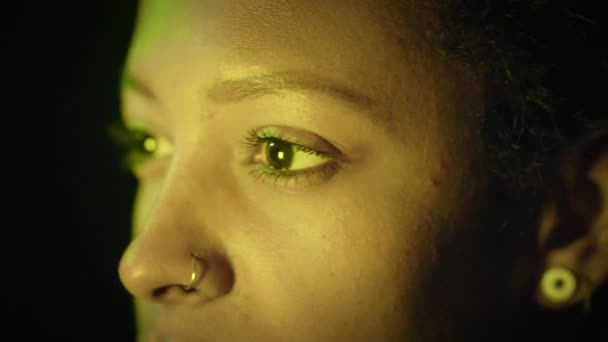 Kvinna ansikte med öppna ögon i färgglada neon ljus TV-nyheter. Söt tjej som ser sig omkring i Modern Studio. Flickande Multi-Colour på huden och ansiktsdrag hos kvinnor. — Stockvideo