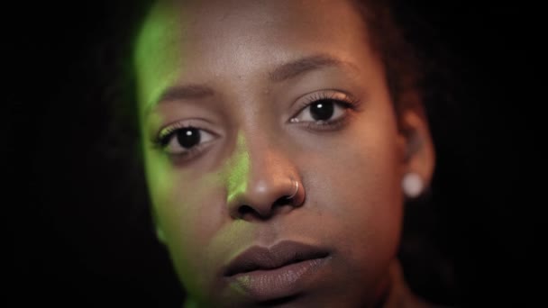 Portrait de fille regardant la caméra dans un éclairage au néon coloré. Multi-couleurs de chambre noire. Publicité futuriste de la mode avec jeune femme. Dame regardant sur la lumière ultra-violette de la nuit — Video