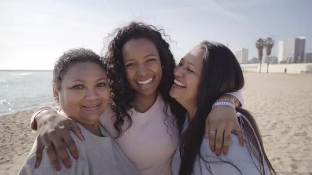 Feliz familia de tres generaciones de mujeres latinas sonriendo y abrazándose riendo mirando a la cámara en la playa al aire libre. Alegre joven adulto crecido hija abrazando maduro de mediana edad mamá vinculación. — Vídeo de stock