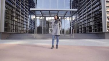 Finans merkezinde genç bir iş kadını telefonda konuşuyor. Kentsel sokak finans merkezi, mutlu kadın işçi açık havada gülümsüyor..