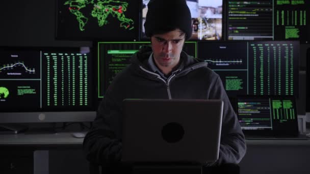 Front Shot van tot Hacker inbreken in Corporate Data Servers van zijn Underground Hideout. Plaats heeft donkere sfeer, meerdere displays — Stockvideo