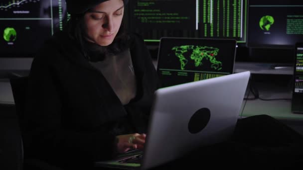 Een vrouw die een cyberaanval doet. Vrouwelijke overtreder hacker inbreken in de overheid data servers in donkere atmosfeer met systeem codes animatie in computers achtergrond. — Stockvideo