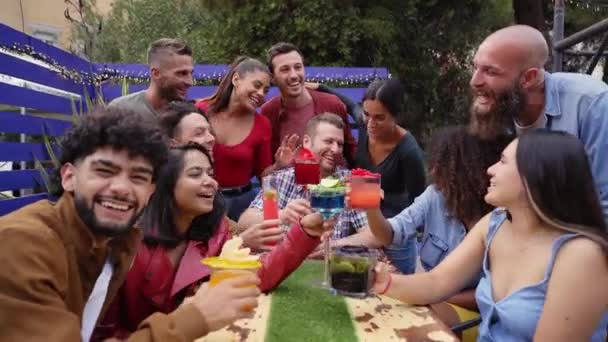 Lidi jásají a baví se. Skupina multiraciálních spokojených přátel popíjení a opékání koktejlů v pivovarském baru střešní terasa restaurace. — Stock video