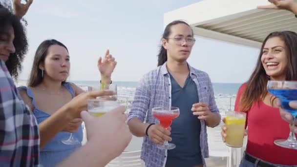 Přátelé na zdraví a baví se pít barevné koktejly v střešním baru. Vtipní lidé tančí na večírku. Máme takové štěstí, že máme jeden druhého. — Stock video