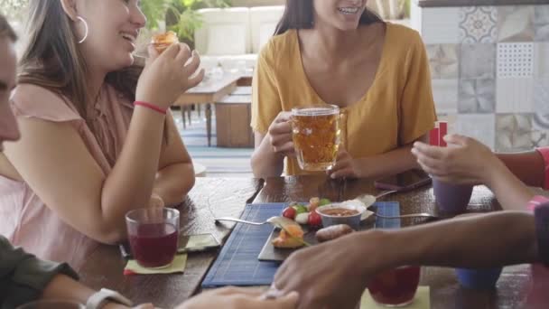 Zeitlupe Multikulturelle Menschen beim Frühstück, Kaffee trinken und jubeln. Fröhliches Gemeinschaftsvergnügen in einer Terrassenbar. Lustige Gruppe von Freunden lacht und prostet Saft zu. — Stockvideo