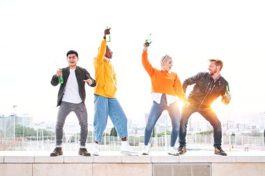 Çeşitli insanlar açık havada dans edip, bira içip eğleniyorlar. Birlikte başarımızı kutlayan mutlu arkadaşlar. Mutluluk ve arkadaşlık kavramı