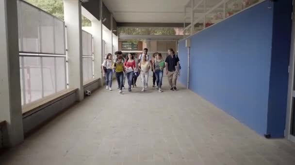 Rallentatore di gruppo di studenti che corrono fuori dall'aula alla fine delle lezioni. Gruppo di studenti del liceo. Adolescenti multietnici. Fine del mandato al liceo, — Video Stock