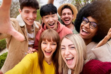 Bir grup neşeli genç arkadaş selfie portresi çekiyorlar. Mutlu insanlar kameraya bakıp gülümsüyor. Toplum kavramı, gençlik yaşam tarzı ve arkadaşlık. Yüksek kalite fotoğraf