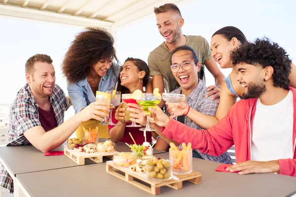 Multiracial Young people holding cocktails drinks. Friends having fun together toasting cocktails at rooftop. Social gathering life style concept — Stock Photo, Image