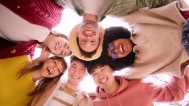 Çemberdeki neşeli genç arkadaşlardan oluşan bir grup selfie portresi çekiyor. Mutlu insanlar kameraya bakıp gülümsüyor. Toplum kavramı, gençlik yaşam tarzı ve arkadaşlık
