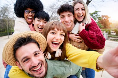 Neşeli bir grup mutlu arkadaş sırtına gülümseyen selfie çekiyorlar. Şehirdeki parkta üç çift birlikte eğleniyor. İnsanlar tatillerde seyahat etmekten hoşlanıyor.