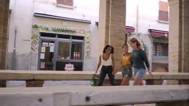 Jonge, gelukkige vrouwen die vrolijk in een straat rennen en opgewonden lachen. Vrolijke mensen maken vakantie in de Europese stad — Stockvideo