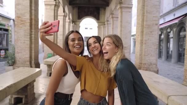 Üç neşeli kız yaz kıyafetleri içinde turistik şehir merkezinde selfie çekiyorlar. — Stok video