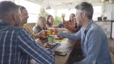 Çok kültürlü insanların kahvaltlarını ve tezahüratlarını yakından izliyorlar. Teras barında mutlu topluluk eğlencesi. Yüksek kalite fotoğraf