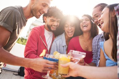Bir grup insan barın terasında birlikte eğleniyor ve gülüyor renkli meyve kokteylleri içiyor ve arkadaşlığın tadını çıkarıyorlar. Yüksek kalite fotoğraf