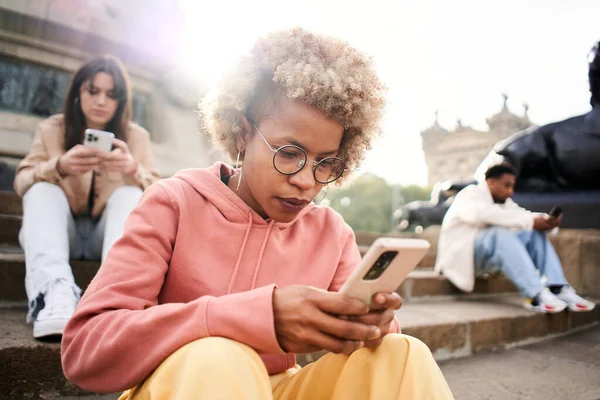 Group of people ignoring each other using phone with serious face. Latina woman focused on their mobile. High quality photo