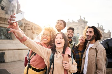 Diverse cultures students taking selfie with mobile phone outdoors. University college people having fun together. High quality photo