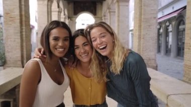 Üç neşeli kız arkadaş yaz kıyafetleri içinde turistik şehir merkezinde selfie çekiyorlar. Yüksek kalite fotoğraf