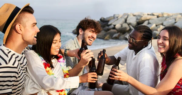 Sunset on the Boardwalk with happy friends at the beach cheering with Beer - Focus on the boy with the hat on the left. High quality photo