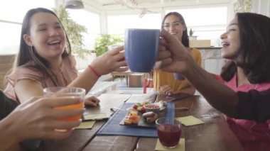 Çok kültürlü insanlar kahvaltlarını yapıp, kahkaha atıyorlar. Teras barında mutlu topluluk eğlencesi. Yüksek kalite fotoğraf