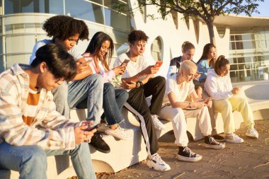 Group of young technology addicts using mobile smartphone outdoor. Multi ethnic millennial generation no social with new trends social media apps. Lens flare. High quality photo