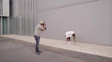 A photographer and a model doing a photo shoot in the street. High quality FullHD footage
