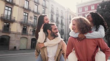 Slow motion of a Two beautiful European couples in piggyback laughing and having fun. Friendship concept . High quality photo