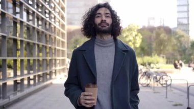 Carefree business man walks happily and smiling down the street against the crowd. High quality 4k footage