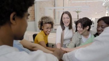 Group of multiethnic business people stacking hands and cheering. High quality 4k footage