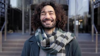 Kafkasyalı genç işadamı gülümseyen kameraya bakıyor. Çalışmanın başarısı için gülümseyen neşeli erkek. Yüksek kalite fotoğraf