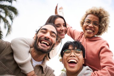 Group of young people looking at the camera outdoors. Happy smiling friends hugging. Concept of community and youth lifestyle. High quality photo