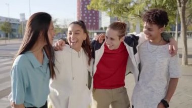 Group of young people having fun together outdoors. Portrait of multiethnic students laughing at the city. High quality photo