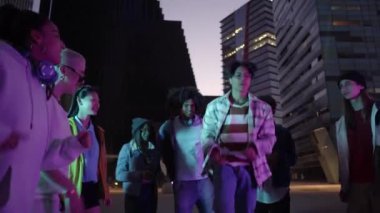 Gece açık havada bir grup dansçı parti veriyor. Mutlu genç çok ırklı arkadaşlar serbest stil hareketleri. Gençlik kültürü, şehir hayatı konsepti. Yüksek kalite 4k görüntü