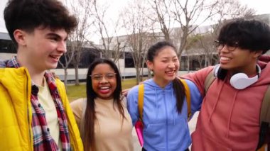 Confident multiracial group of students holding books and smiling at camera, campus university on background, learning and education concept. Smiling happy people having fun together. International