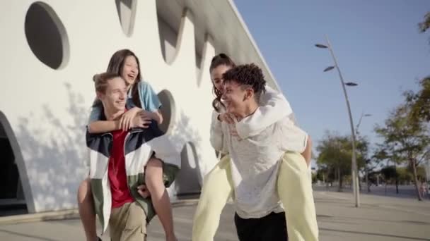 ピギーバックをして街の通りに手を積み重ね 休暇中の100年の友人 若者グループは一緒に屋外で笑って時間を楽しんでいます 高品質の写真 — ストック動画