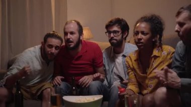 Futbol hayranları, Stylish Loft Apartment 'da bir kanepede rahatlar, Evde Spor Maçı izlerler. Heyecanlı Genç Arkadaşlar En İyi Futbolcuları İçin Tezahürat Yapıyor, Oyuncuların Gol Sayısını Kutluyor