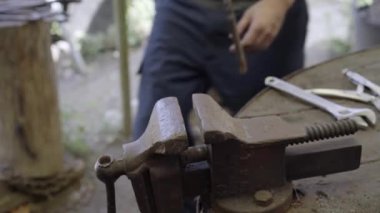 Demirciyi demir ocağında çekiçle çalışan bir demirciye yaklaştır. Yüksek kalite 4k görüntü