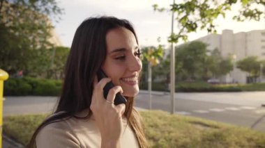 Cep telefonuyla konuşan mutlu bir kadın. Arkadaşlarıyla gülüyor, beyaz dişleriyle gülüyor, yakın plan çekimleri yapıyor. Öğrenci kız dışarıdaki akıllı telefondan sipariş veriyor, tatmin olmuş..