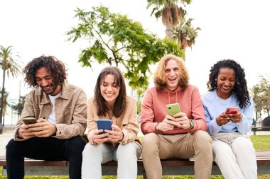 Herkesin telefonlarını kullandığı arkadaş grubunda bir adam kameraya bakıyor. Yüksek kalite fotoğraf