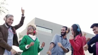 Bir grup iş arkadaşı kutlama yapıyor. Neşeli insanlar gün batımında dışarıda dans ediyorlar. Kulaklıklı genç milenyumlar müzik dinliyor. Yüksek kalite fotoğraf