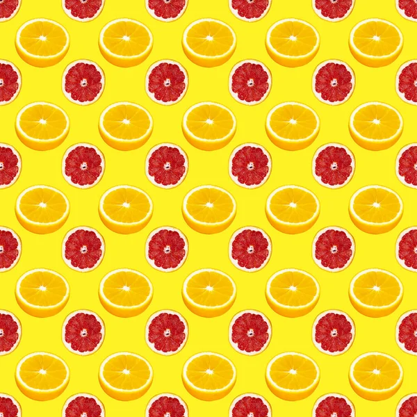 Fresh orange and grapefruit slices seamless pattern over yellow background, top view — Stock Photo, Image