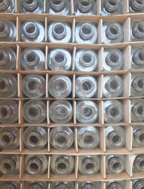 Cam, şeffaf, boş şişeler içinde hücreler olan karton bir kutuda. Yukarıdan bak. Geri dönüşüm camı için arka plan ya da reklam olarak kullanılacak. Telefonla çekiliyor.