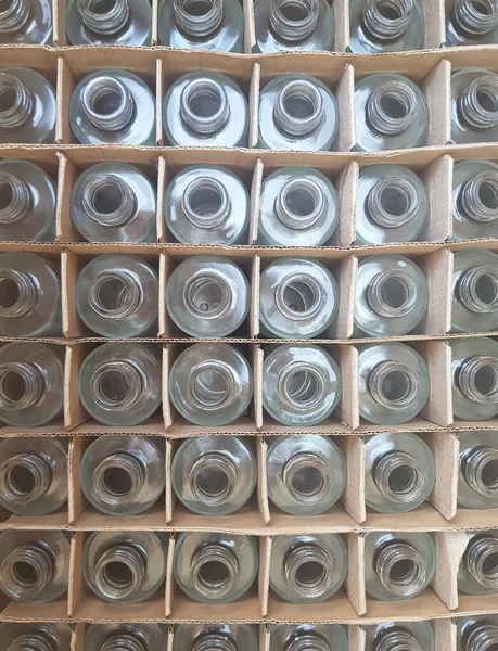 Cam, şeffaf, boş şişeler içinde hücreler olan karton bir kutuda. Yukarıdan bak. Geri dönüşüm camı için arka plan ya da reklam olarak kullanılacak. Telefonla çekiliyor.