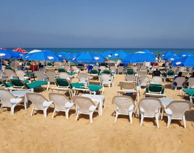 İsrail plaj manzaralı güneşli yataklar, şemsiyeler ve deniz. Telefonla çekiliyor.