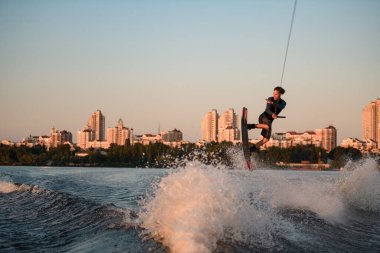 Aktif bir adamın Wakeboard 'da dalgalanan dalgaların üzerinden ustaca atlayışını görmek inanılmaz.