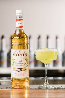 UKRAINE, KYIV - 12 Mart 2021: Monin Vanilla şurubu şişesi ve parlak lezzetli bir kokteyl kristali